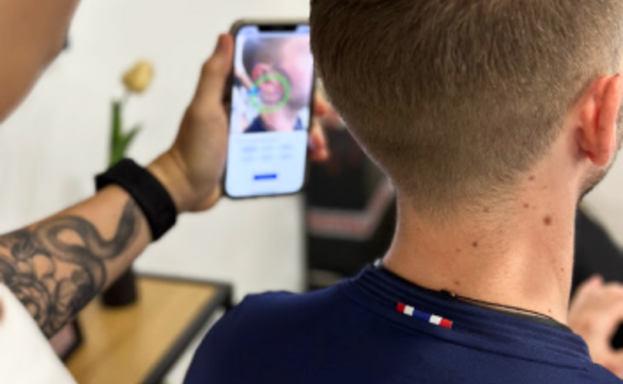 The Adapto Scan app is shown as it is scanning a man's ear